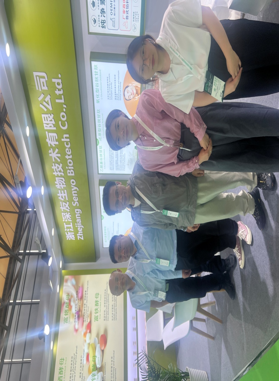 Five people posing for a group photo at the Senyo booth.